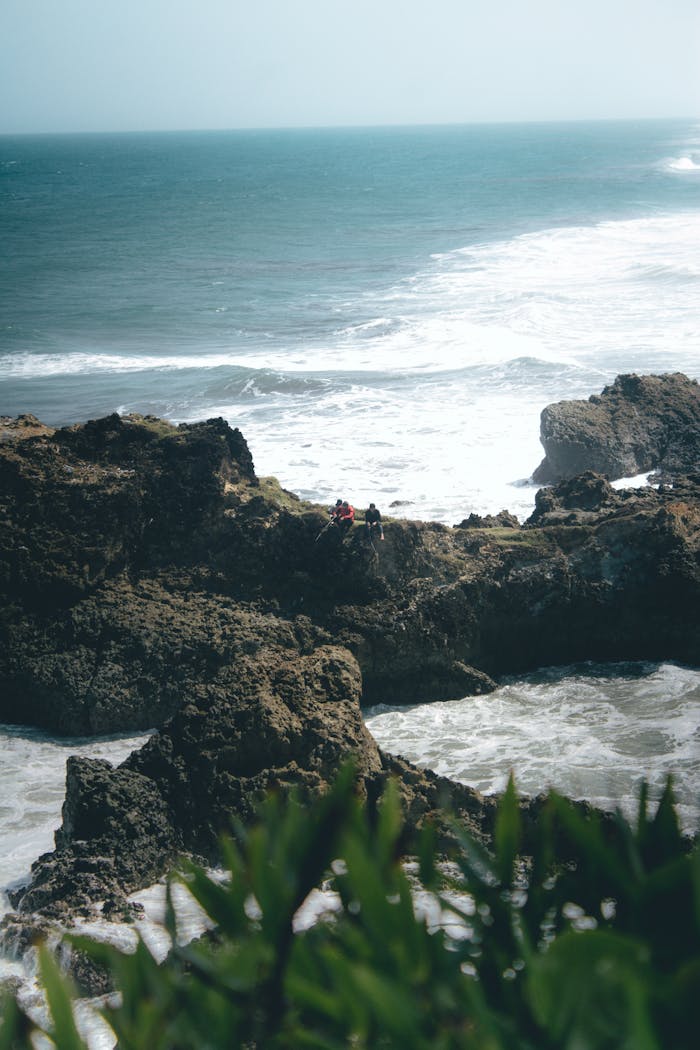 Dramatic rocky coastline with ocean waves in Tasikmalaya, Indonesia, perfect for travel inspiration.